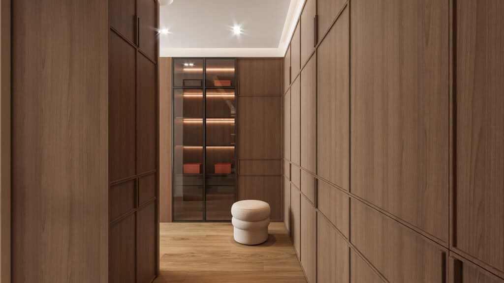 Sleek modern wooden walk-in closet with glass display cabinet and plush ottoman, contemporary interior design designbliss malaysia.