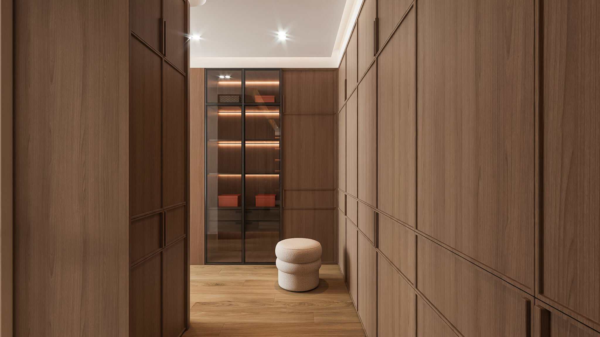 Sleek modern wooden walk-in closet with glass display cabinet and plush ottoman, contemporary interior design designbliss malaysia.