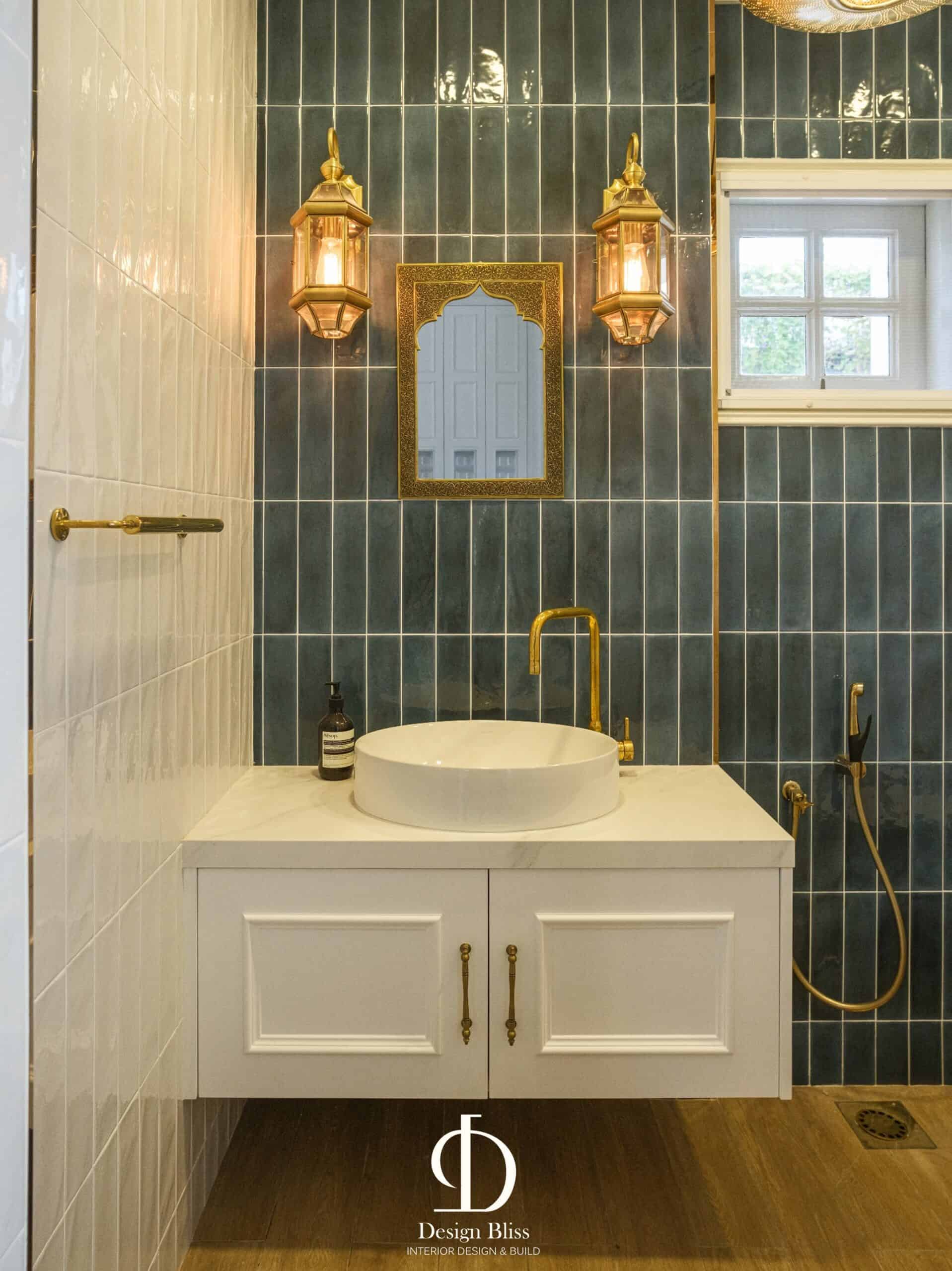 Véra Maison bathroom with deep blue wall tiles, white vanity and gold-toned lighting