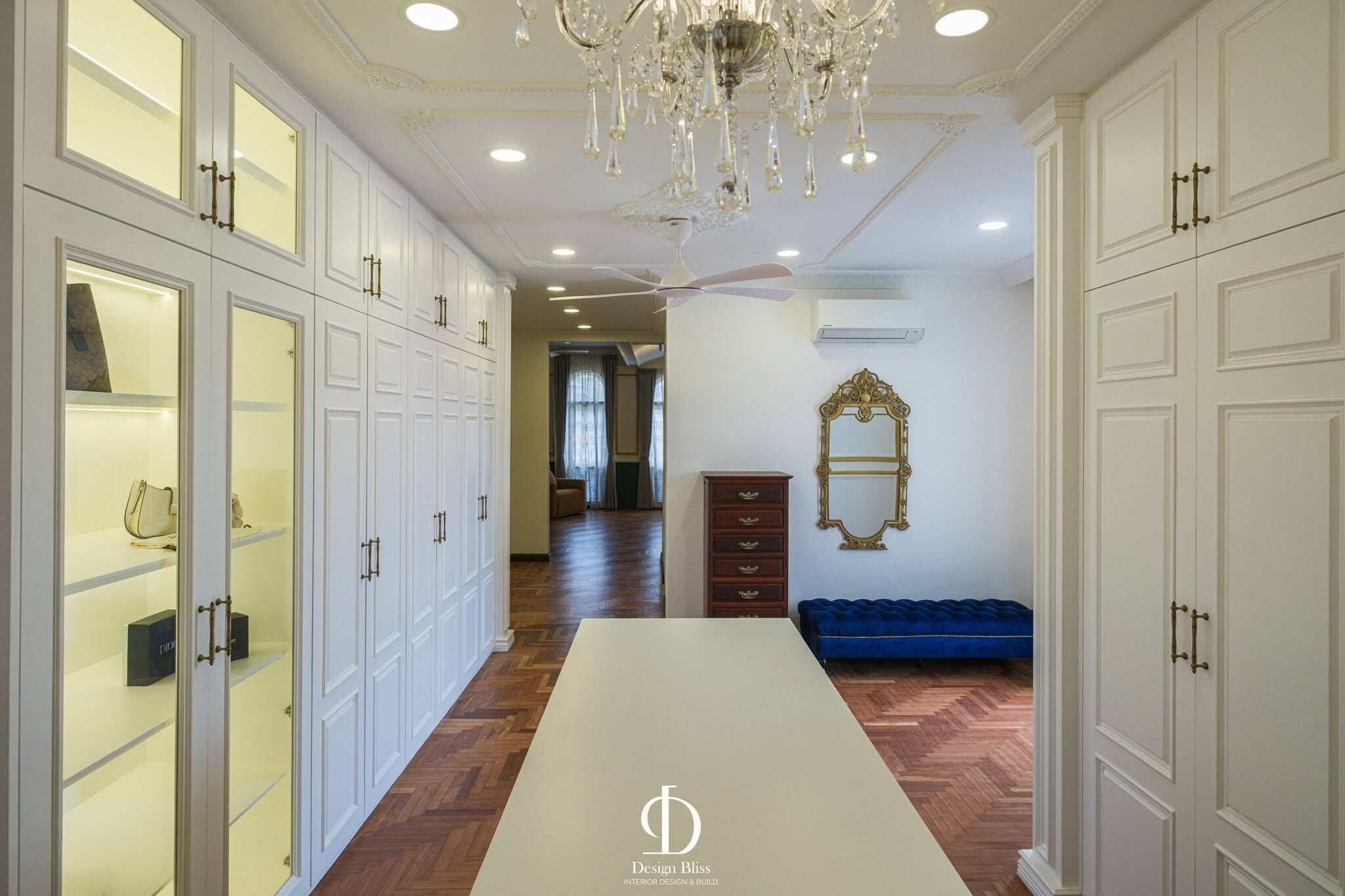 Véra Maison luxury walk-in wardrobe with white cabinetry, central island and chandelier