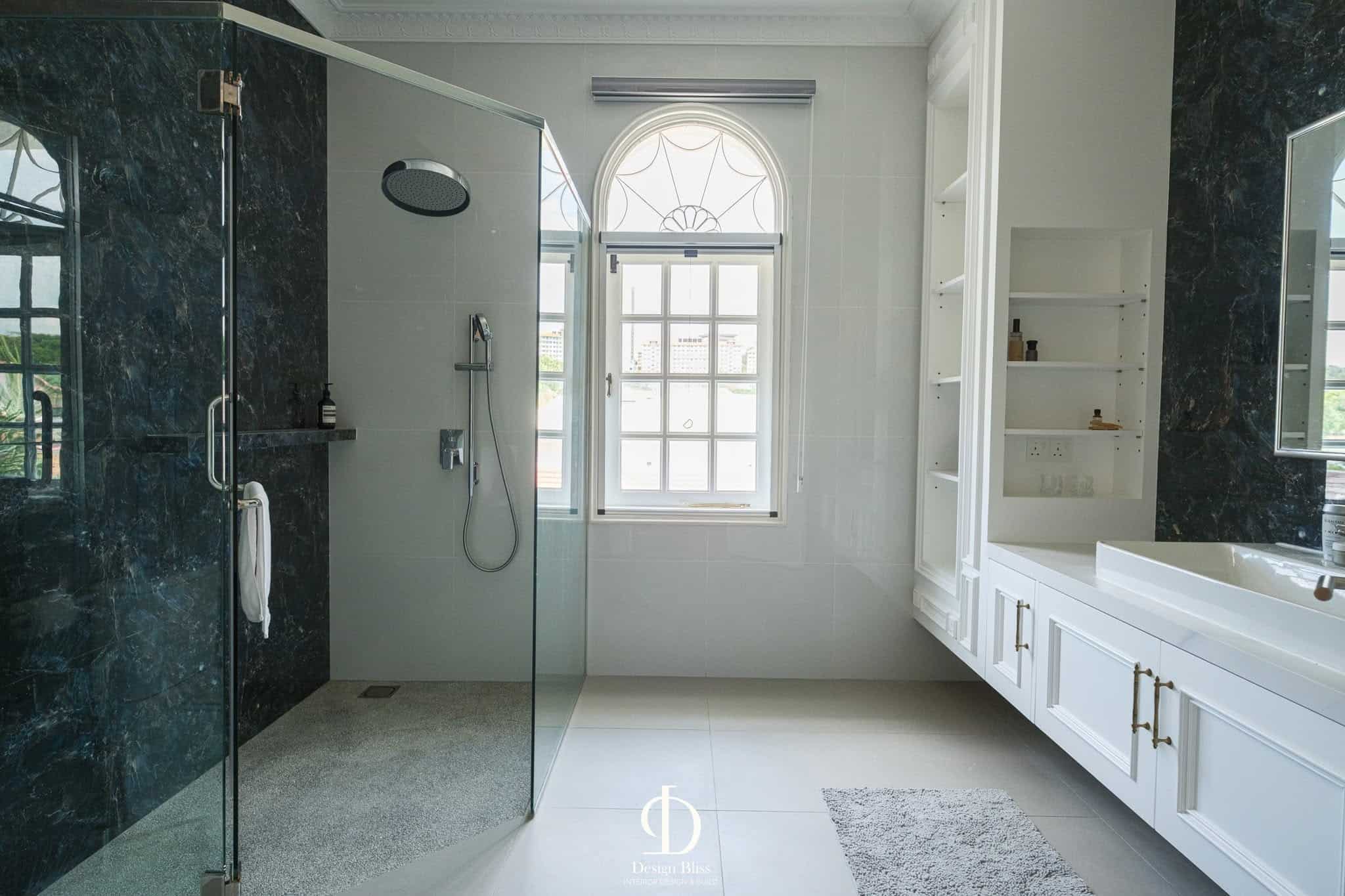 Véra Maison master bathroom with glass shower, dark marble surfaces and white vanity