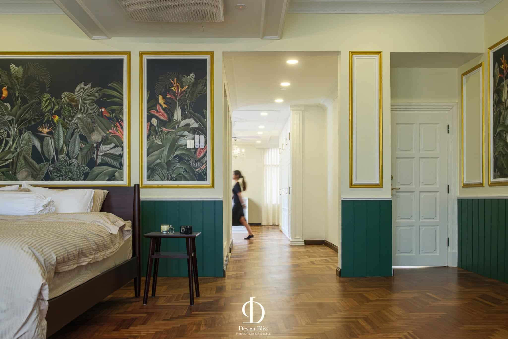 Véra Maison master bedroom with tropical botanical artwork, green panelling and warm timber flooring