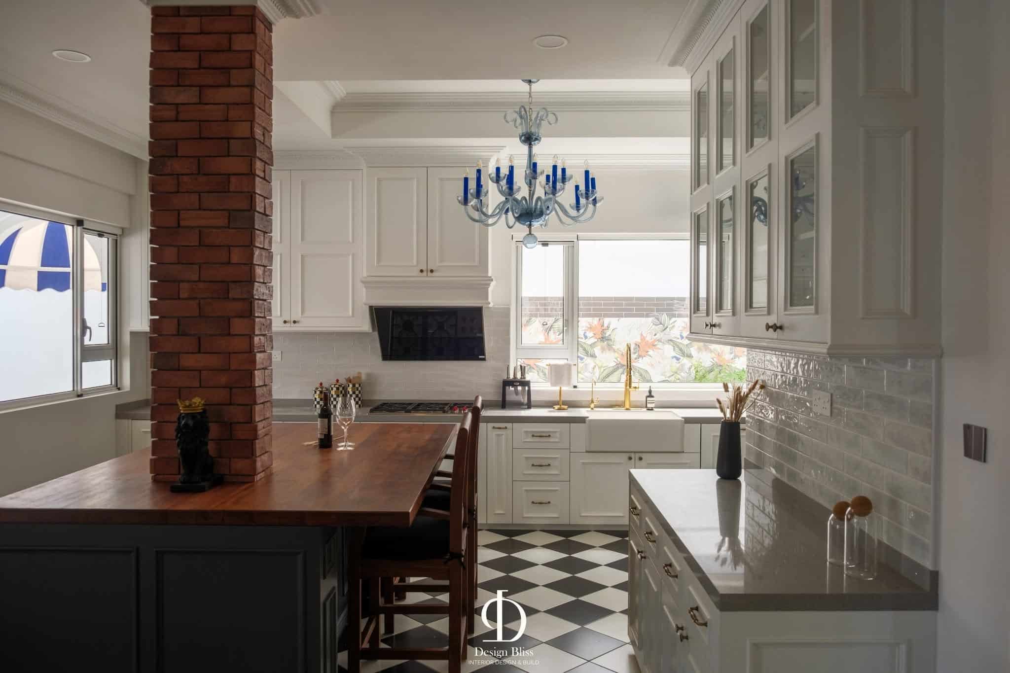 Wide view of the Véra Maison kitchen with dark island, white cabinetry and checked flooring